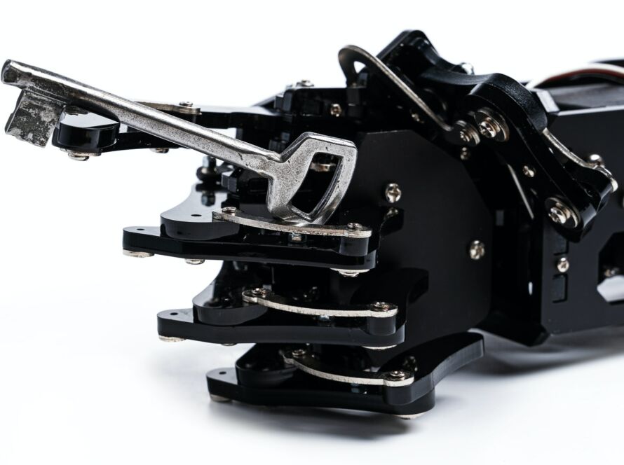 Real robotic hand and vintage key. Concept of encryption and data security by AI
